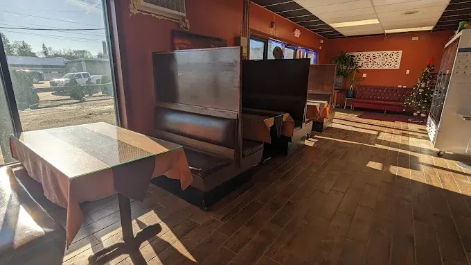 Booth seating in Pada Thai's dining room, with terracotta walls and warm wood tones